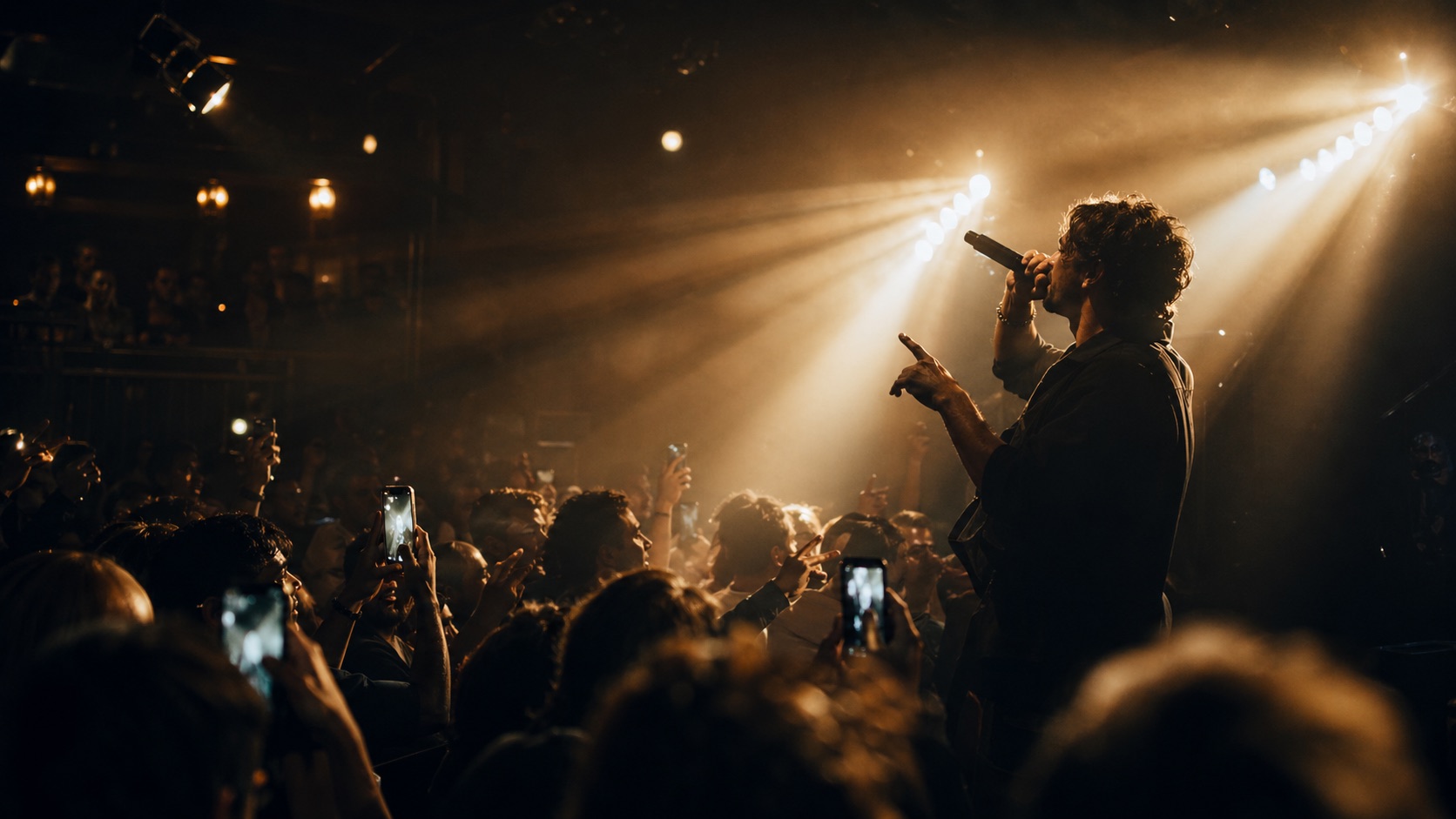 Live event scene with cinematic stage lighting and audience silhouettes
